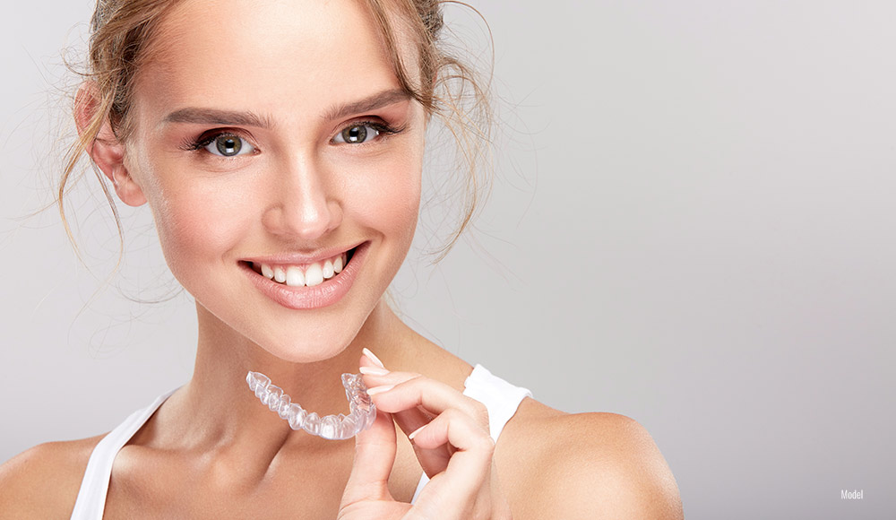 Female holding Invisalign® in her hand