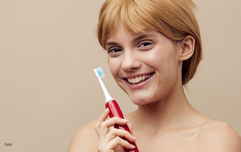 Female holding electric tooth brush in her hand