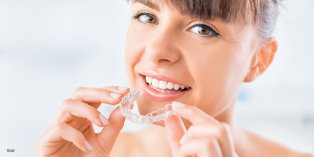 Female holding Invisalign® in her hand